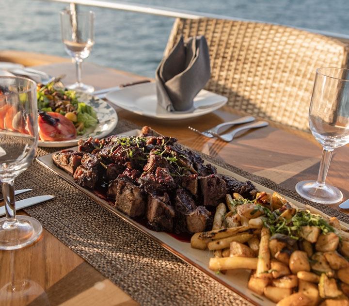 Steak and grilled vegetables served at sunset on a Cabo San Lucas yacht charter