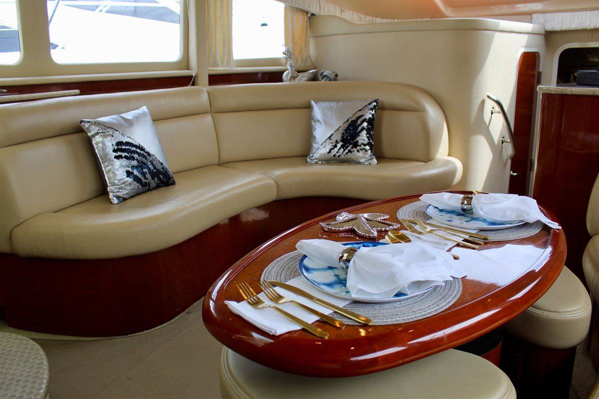 Sea Ray yacht salon interior with leather seating and a set dining table in Cabo San Lucas